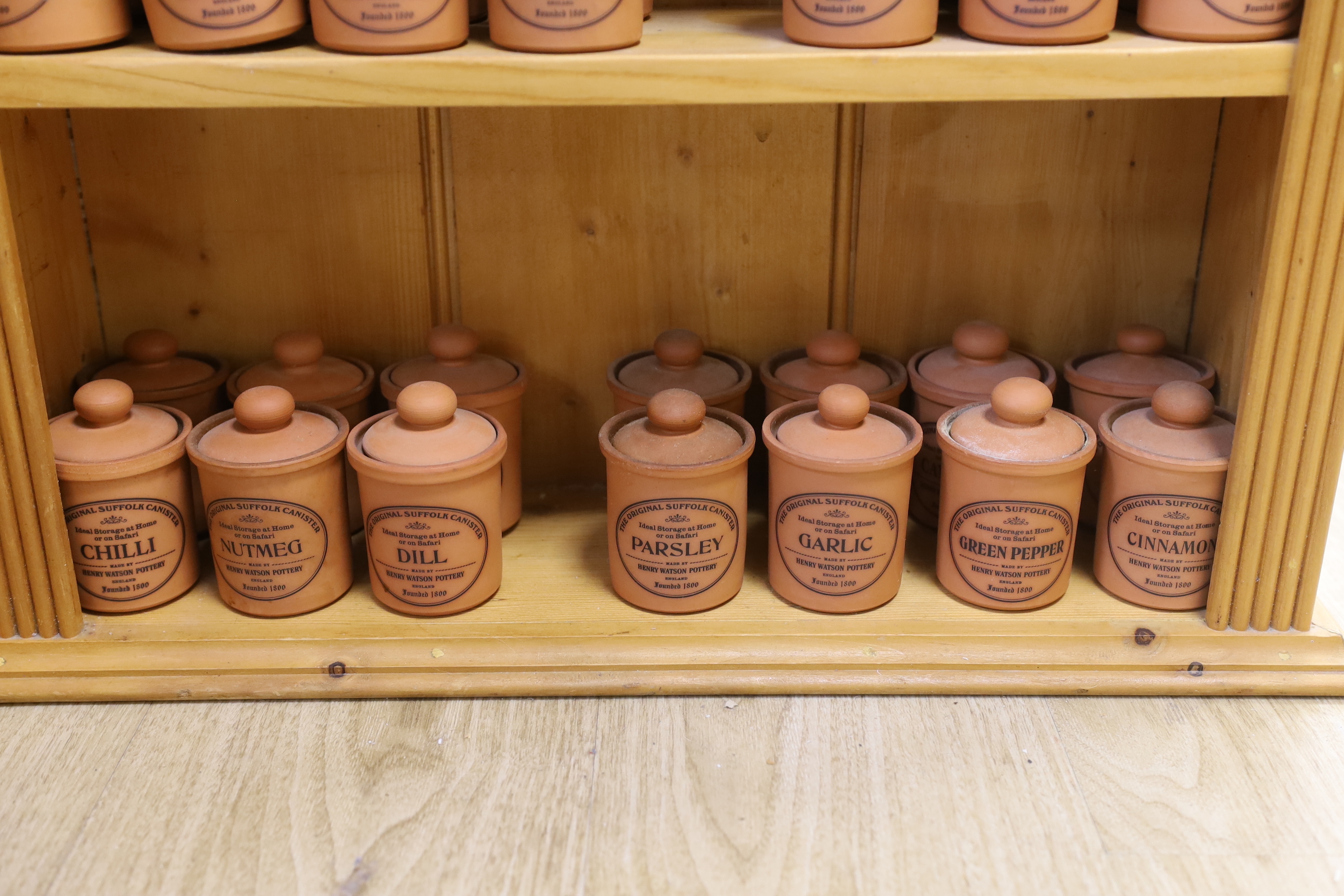 A pine kitchen spice rack with Henry Watson Pottery ‘Original Suffolk Canister’ set